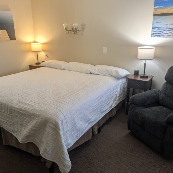 Early American Motel Deluxe King bedroom with two chairs