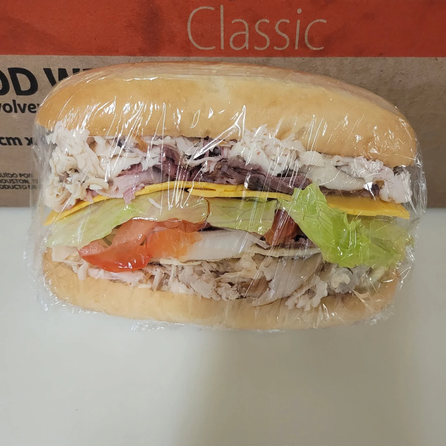 Wrapped roll sandwich with meat, cheese, lettuce and tomato