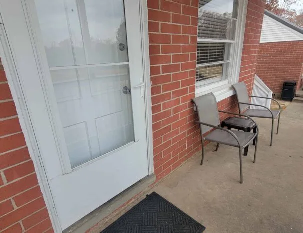 Covered porch seating outside an Early American Motel cabin