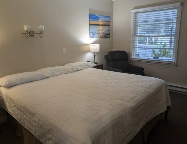 A king bed, bedside lamp and seating in the Deluxe King room