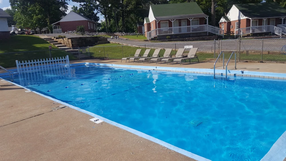 Early American Motel’s outdoor pool, lounge chairs and red-brick buildings
